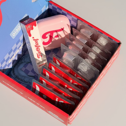 Open box containing Toothfloof dental products including a pink container and Orawrap teeth whitening wraps with visible branding. The ultimate teeth whitening kit