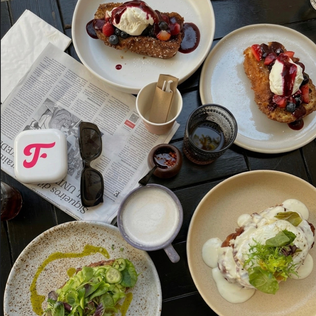 Table with various dishes of food including plates of food, a cup, and a newspaper. Toothfloof White Dental Orawrap Tray Storage Case